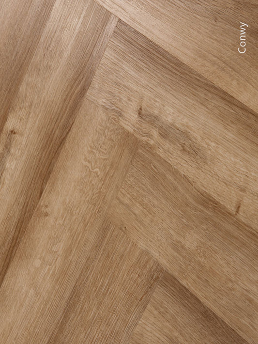 Conwy 8mm herringbone hybrid flooring with a realistic timber look, waterproof construction, scratch-resistant wear layer, and classic parquet design for stylish residential and commercial spaces.