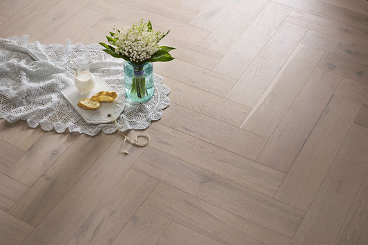 Alpine herringbone engineered oak timber flooring by Coswick featuring a light natural oak finish, durable hardwood construction, and timeless parquet design for residential and commercial interiors.