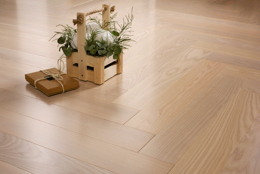 Moonlight herringbone engineered oak timber flooring by Coswick featuring a soft light oak finish, durable hardwood construction, and timeless parquet design for residential and commercial interiors.